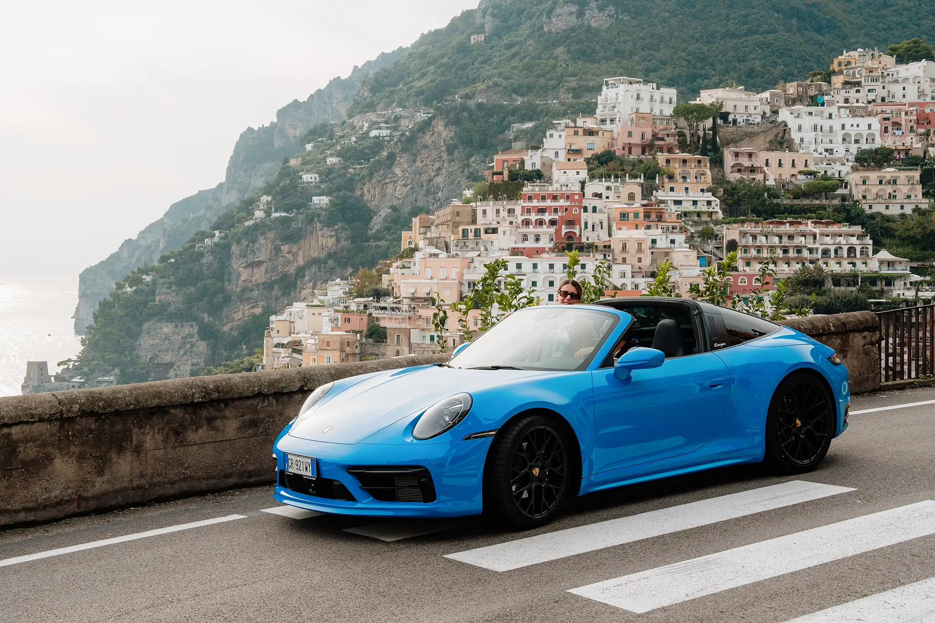 Couple driving a Porsche 911 along the roads of the Amalfi Coast