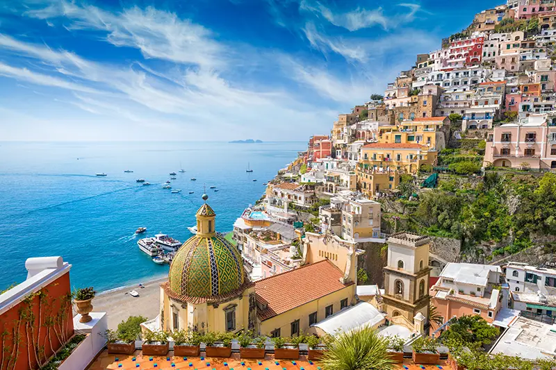Dome of Santa Maria Assunta and panoramic view of Positano’s vertical townscape.